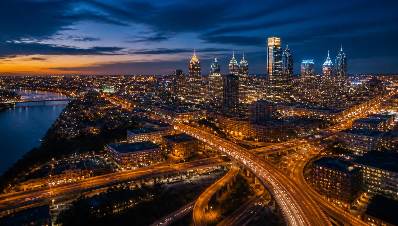 Aerial twilight view of an American city with highways and lit downtown towers